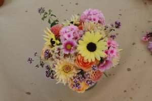 Vase with oregano flower, phlox, dahlias, roses, cosmos and sunflowers